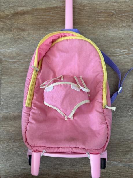 Batoh s bábikou na kolieskach,