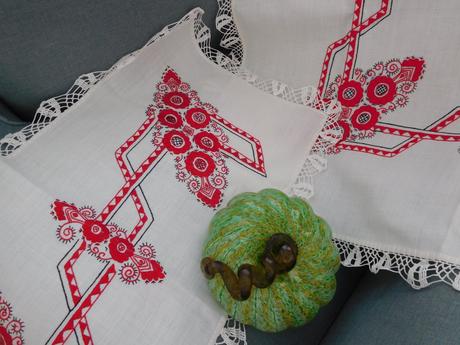 Červená ručná výšivka na bielom podklade,