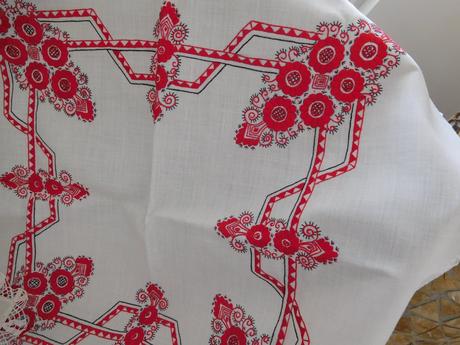 Červená ručná výšivka na bielom podklade,