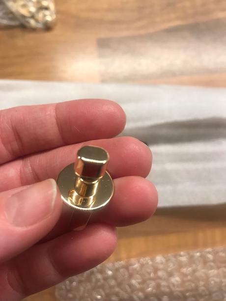 Zámok na kabelku zlatej farby,