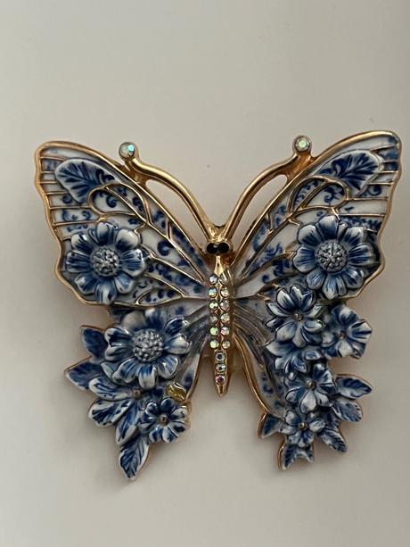 Krasna brosna motyl modro biely,