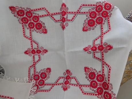 Červená ručná výšivka na bielom podklade,