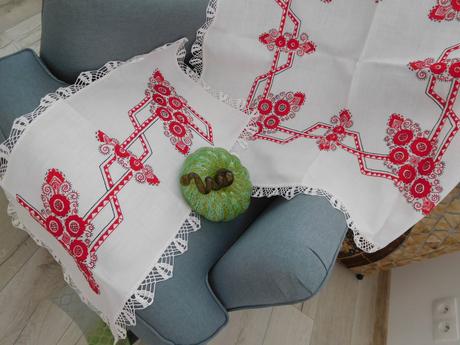 Červená ručná výšivka na bielom podklade,