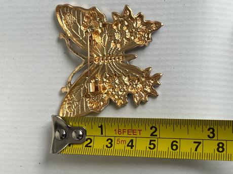 Krasna brosna motyl modro biely,