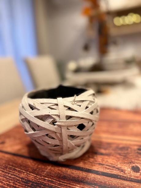 Biely kvetináč ratanového vzhľadu,