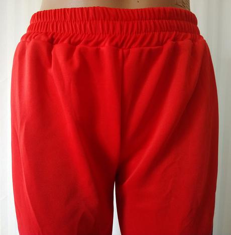 Červené tepláky s čierny a bielym pásikom, s