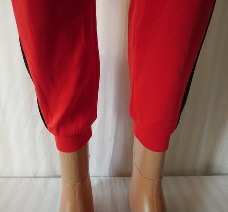 Červené tepláky s čierny a bielym pásikom, s