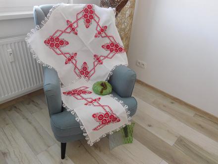 Červená ručná výšivka na bielom podklade, 