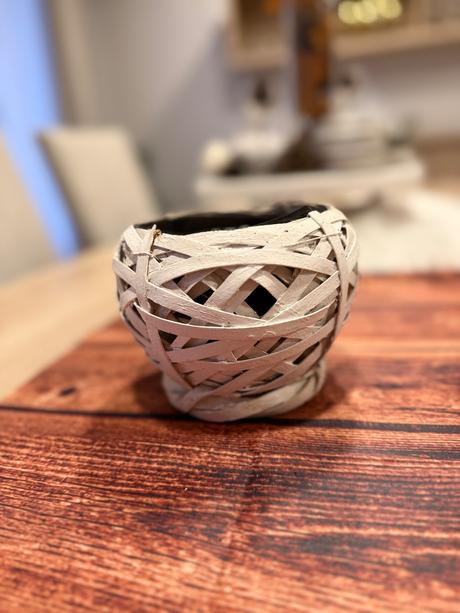 Biely kvetináč ratanového vzhľadu,