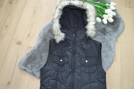 Štýlová zateplená čierna vesta s kapucňou a kožuši, s