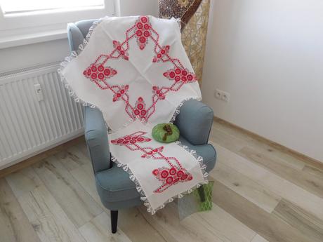 Červená ručná výšivka na bielom podklade,