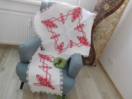 Červená ručná výšivka na bielom podklade,