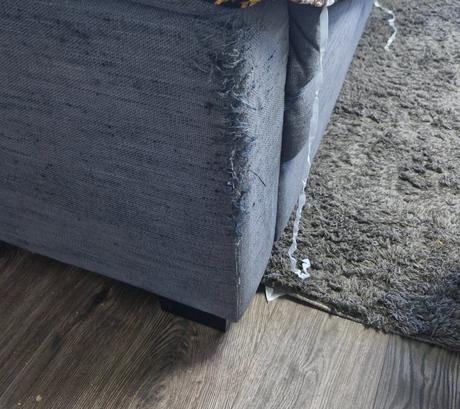 Starší šedomodrý pohodlný gauč,